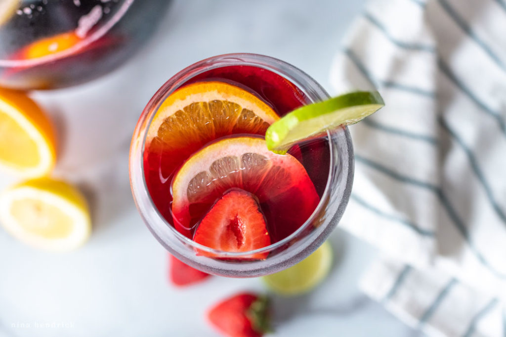 overhead view of sangria cocktail with citrus and strawberries